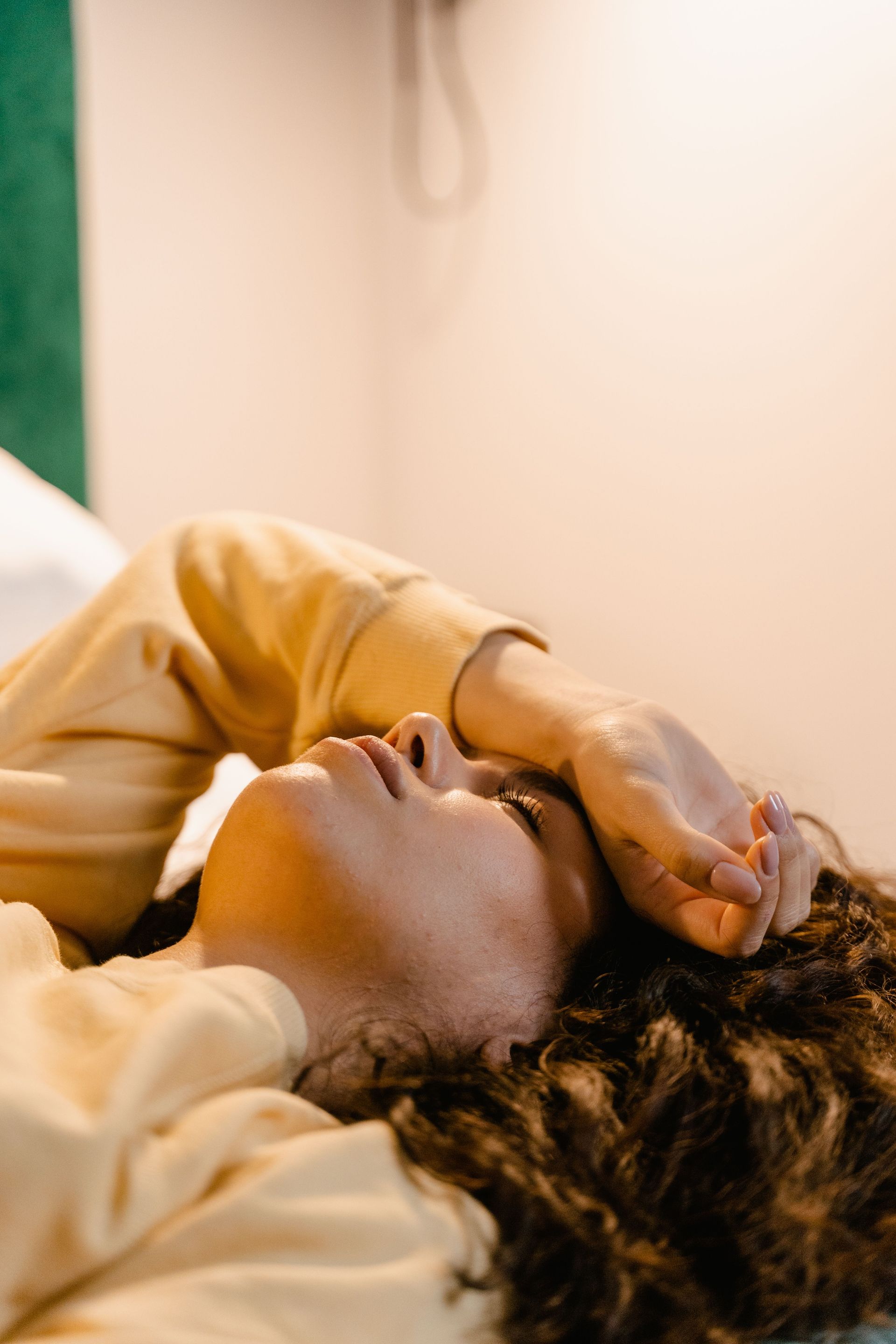 Woman relaxing on bed in casual clothes, embodying tranquility and comfort.